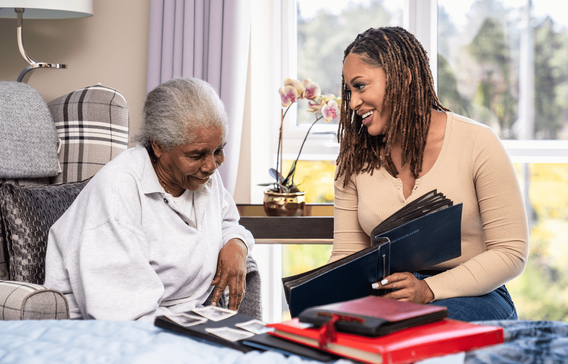 A resident and relative looking at old photos to help with dementia